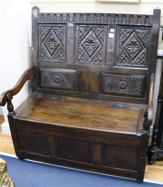 A 17th century style oak monks bench, W.109cm